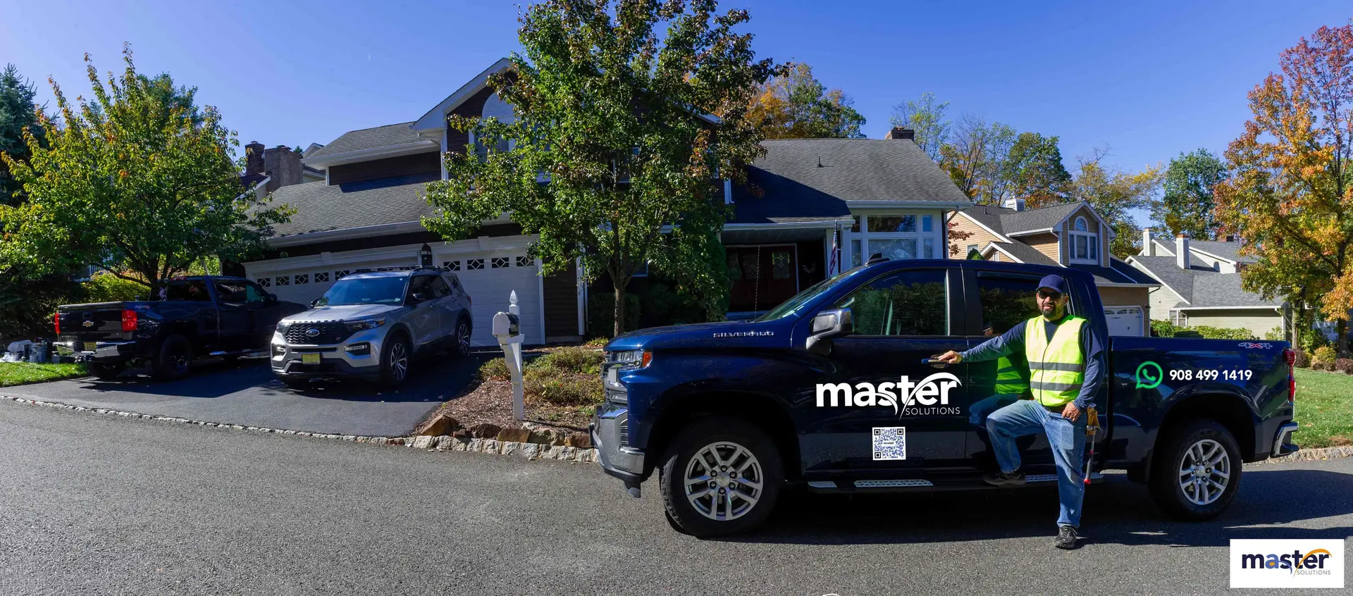 Manrique Castro with the Master Solutions truck and work equipment in front of a New Jersey home